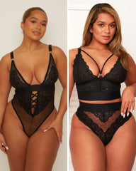 Woman wearing black lace lingerie set on a plain background
