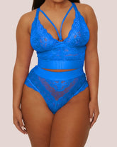 Blue lace lingerie set on a model against a beige background