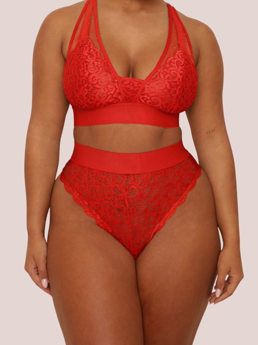 Model wearing the Hallie Bralette and Brazilian Brief Set in Chilli Pepper Red from Tutti Rouge. The set features a supportive lace bralette with sheer mesh panels and matching high-waisted Brazilian briefs.