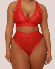 Model wearing the Hallie Bralette and Brazilian Brief Set in Chilli Pepper Red from Tutti Rouge. The set features a supportive lace bralette with sheer mesh panels and matching high-waisted Brazilian briefs.