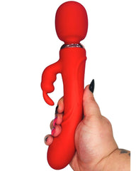 Red silicone toy held by a hand on a white background