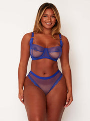 Woman wearing a blue lingerie set against a white background