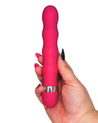 Pink vibrator held by a hand on a white background