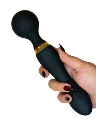 Black handheld device with gold accent held by a hand on a white background