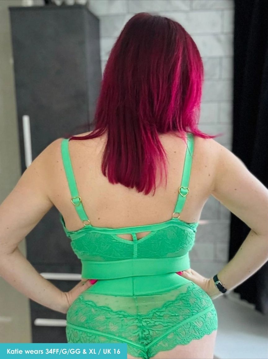 Person wearing a green lingerie set with visible text indicating size and brand.