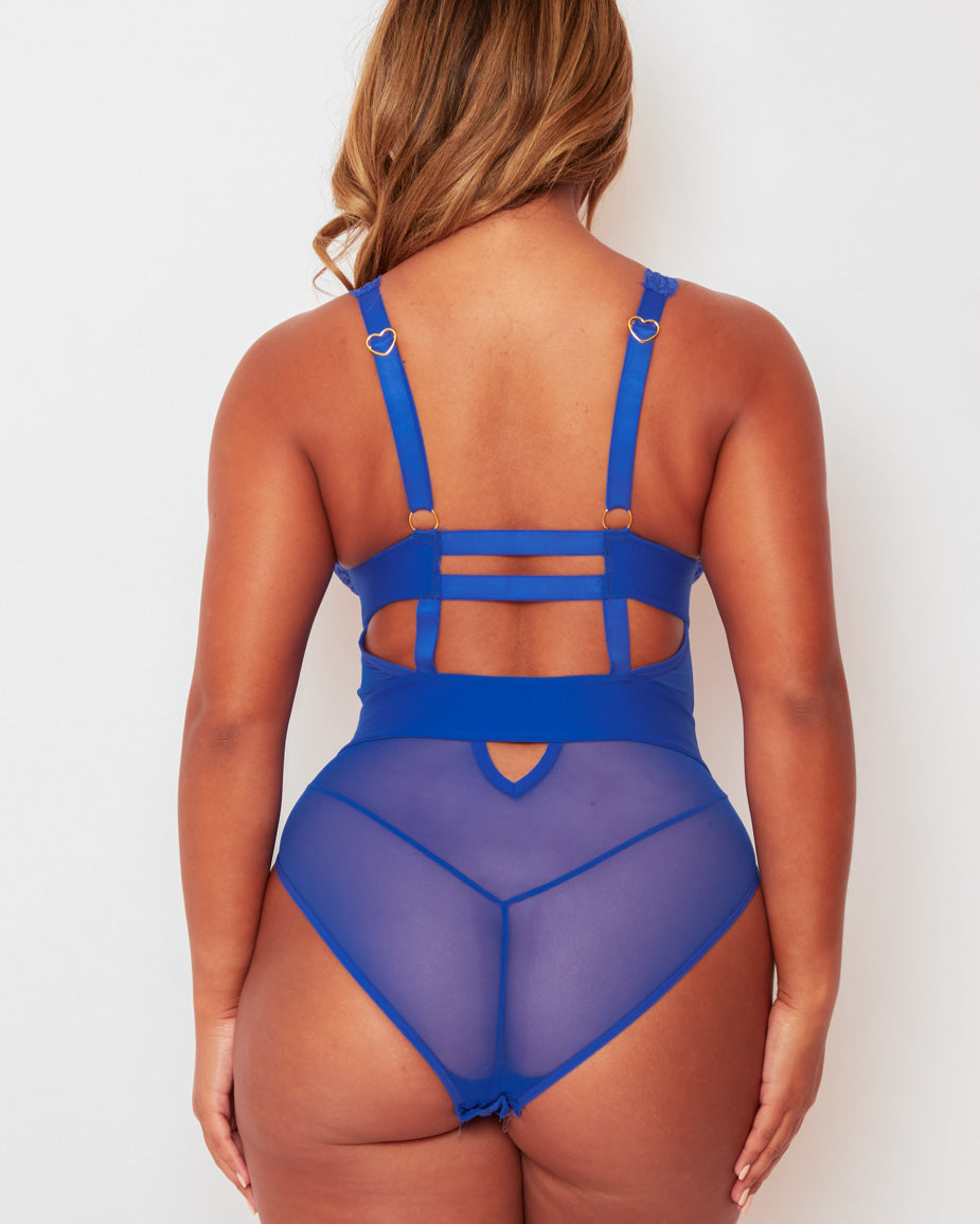 Back view of the Alicia Fuller Bust Curvy Girl Bodysuit in Bluebird Blue, showcasing adjustable shoulder straps with gold-tone heart hardware, strappy cut-out back detailing, and semi-sheer mesh rear panels.
