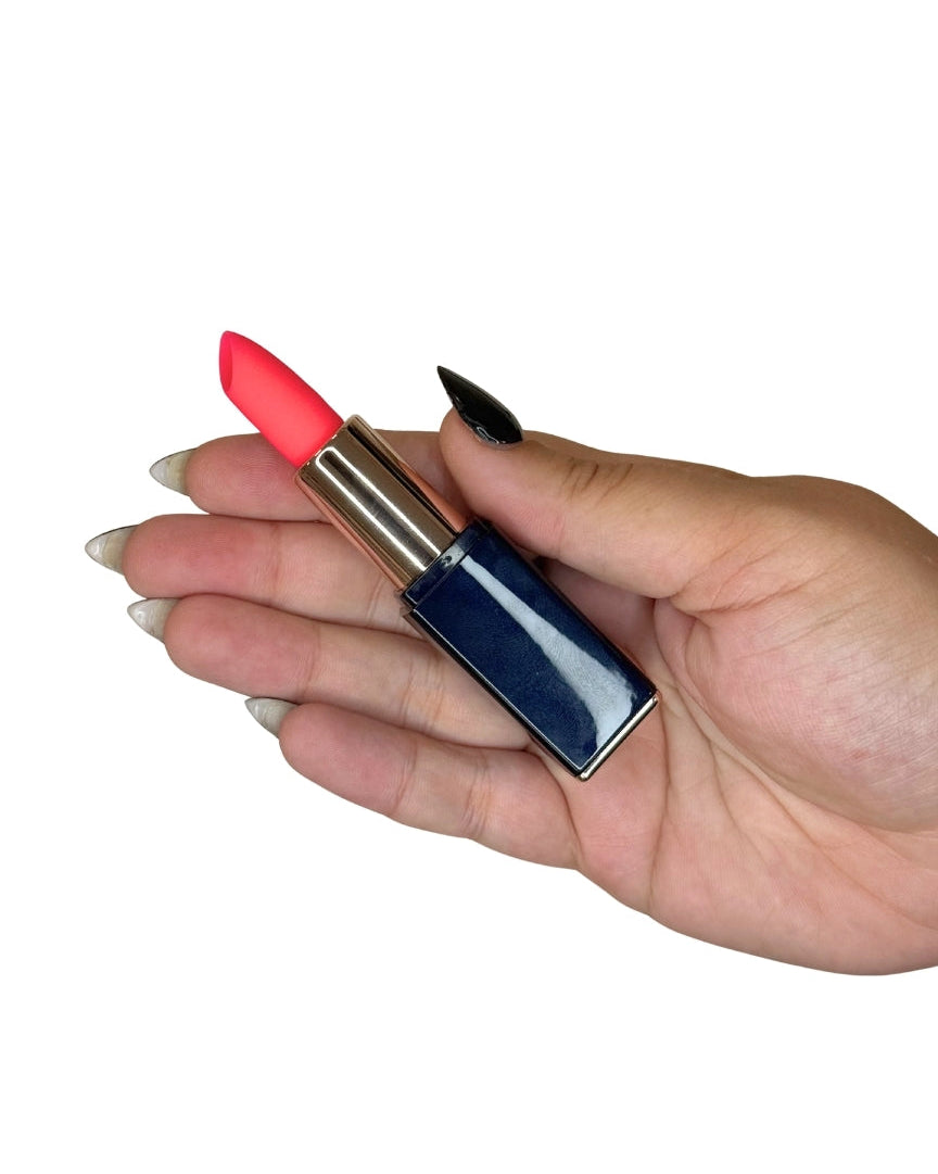 Hand holding a red lipstick discrete vibrator with a blue case on a white background