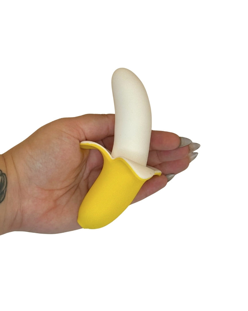 Hand holding a yellow banana-shaped object against a white background