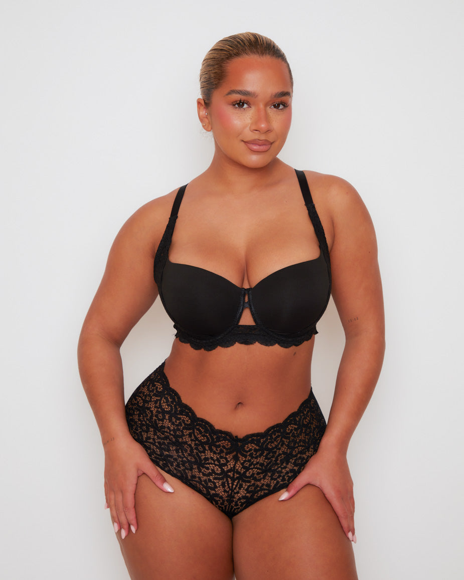 Front view of the Daley T-Shirt Bra and Venus Short in Midnight Black, featuring smooth moulded cups, elegant floral lace detailing, and a subtle centre-front keyhole. The matching lace short offers flattering coverage with a soft scalloped waistband.