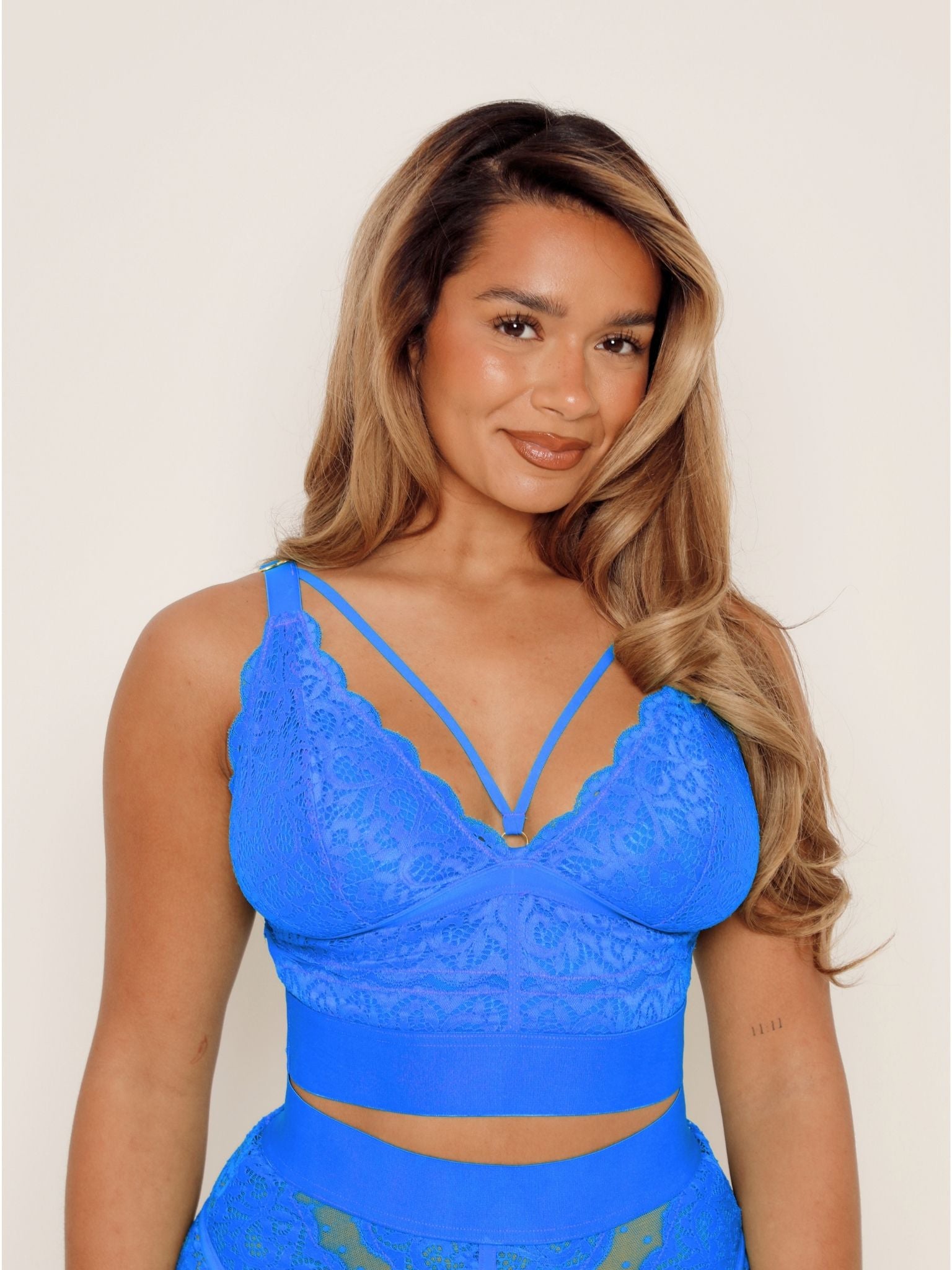 Curve model wearing the Gia Bralette and Francine Thong in Dazzling Blue, featuring supportive wireless lace cups, decorative front straps, and matching lace thong.