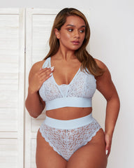 Model wearing the Hallie Bralette and Brief set in Ballad Blue, showcasing delicate all-over lace, sheer mesh inserts, and a flattering high-waisted brief design with scalloped lace edging.