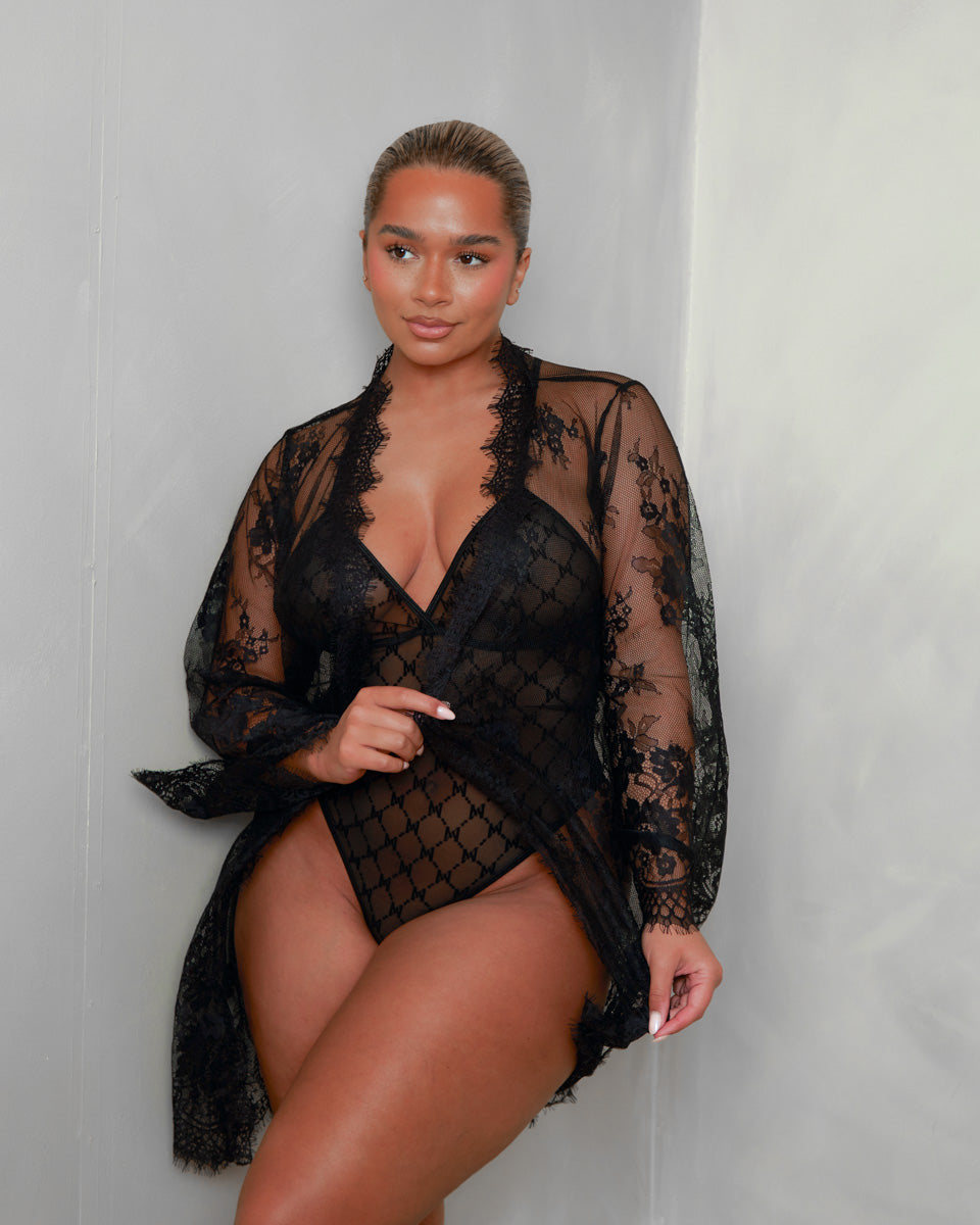 The Tutti Boudoir Kaylee Bodysuit in Onyx Black paired with the coordinating lace robe, showcasing sheer fabrics, elegant eyelash lace trim and a sophisticated layered boudoir style.