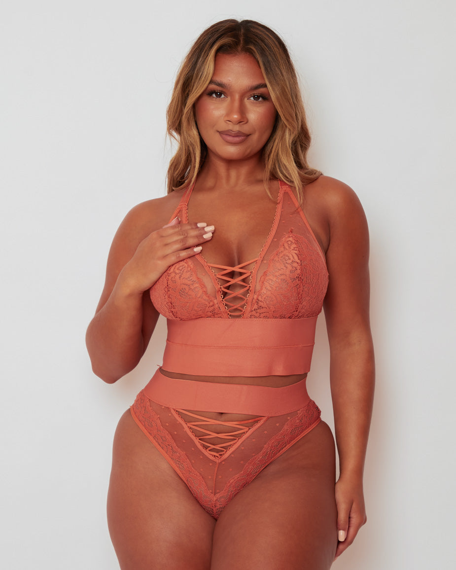 Front view of the Maya Bralette & Brief Set in Cider Orange, showcasing delicate floral lace, sheer dotted mesh, and elegant lace-up detailing that creates a flattering, feminine silhouette.
