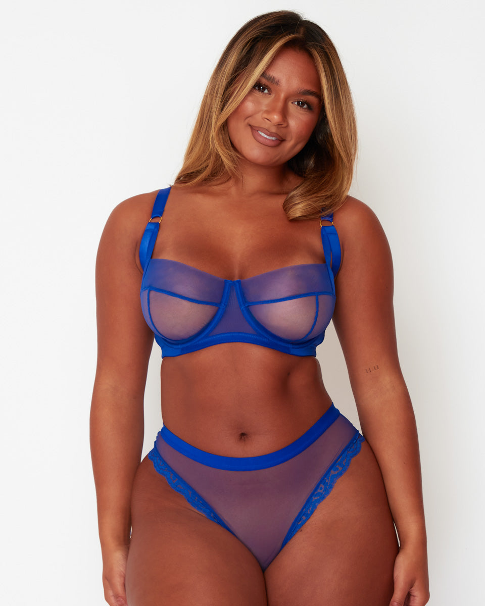 Model wearing the Tutti Rouge Raya Cobalt Blue fuller bust lingerie set, featuring a supportive sheer mesh balcony bra with matching Brazilian brief, designed to flatter curvy figures and DD+ cup sizes.